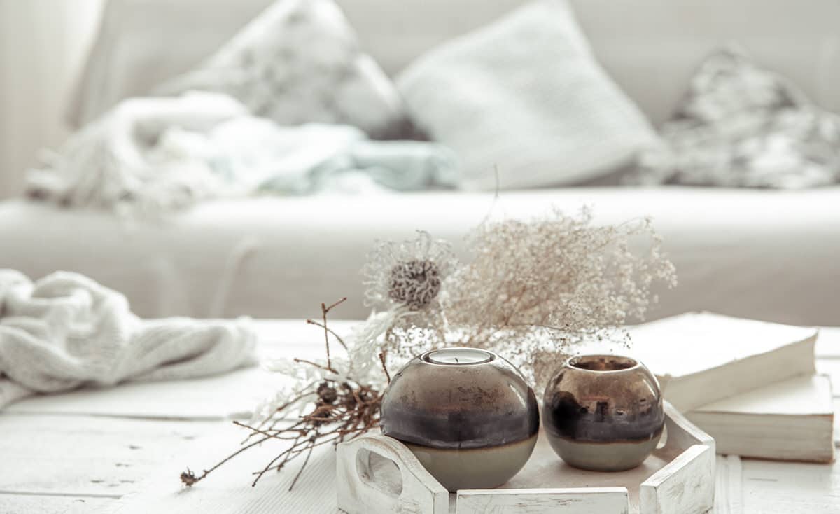Details of the decor on the table in the living room in a hygge style. The concept of home comfort and modern style.