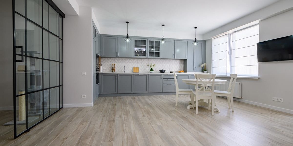 Trendy grey and white modern kitchen furniture in studio apartment Trendy grey and white modern kitchen with white round dining table in studio apartment